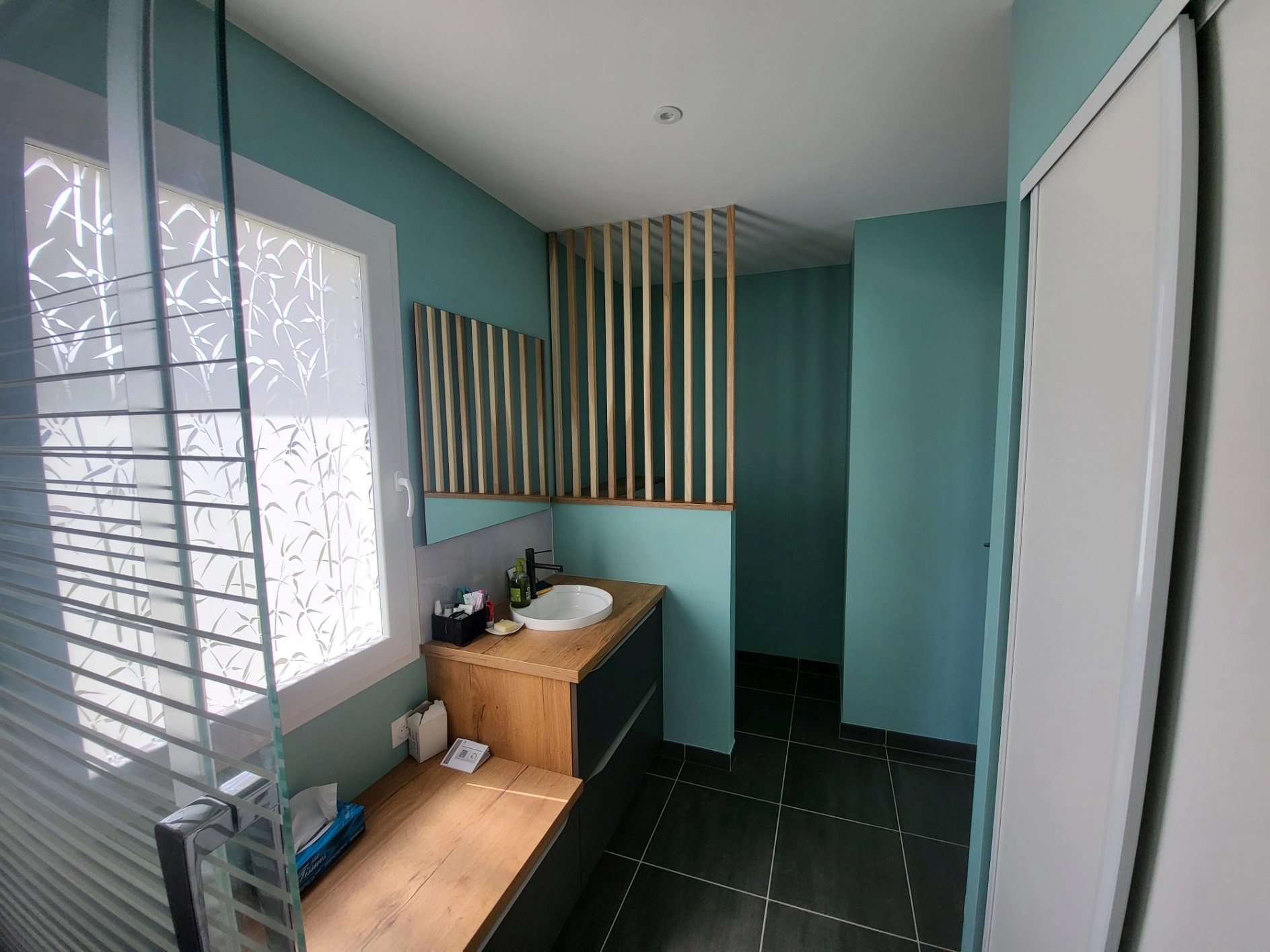 Salle de bain avec assise intégrée et claustra décoratif séparant les espaces