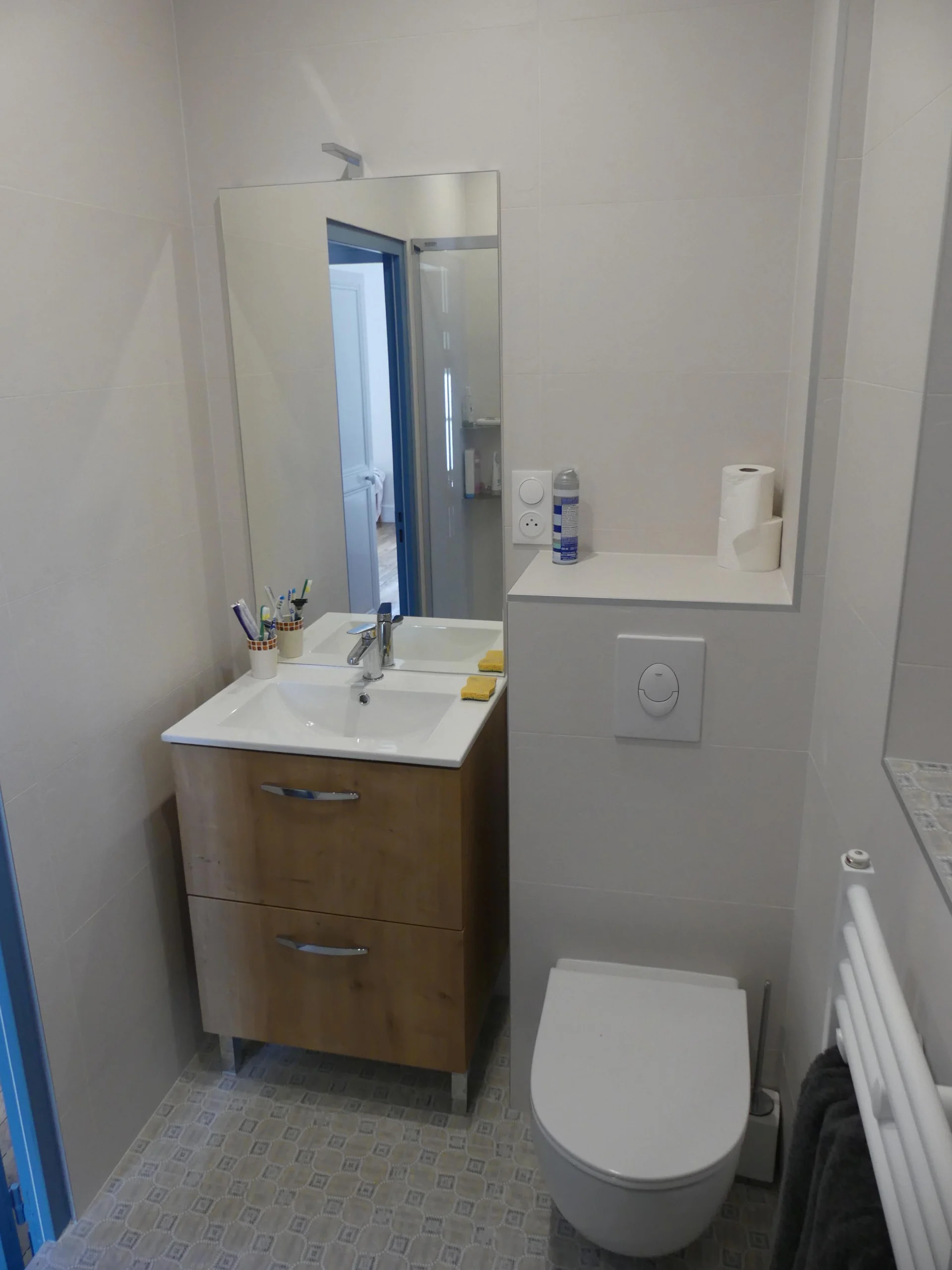 Salle de bain blanche fonctionnelle dans un logement locatif, au style simple et pratique
