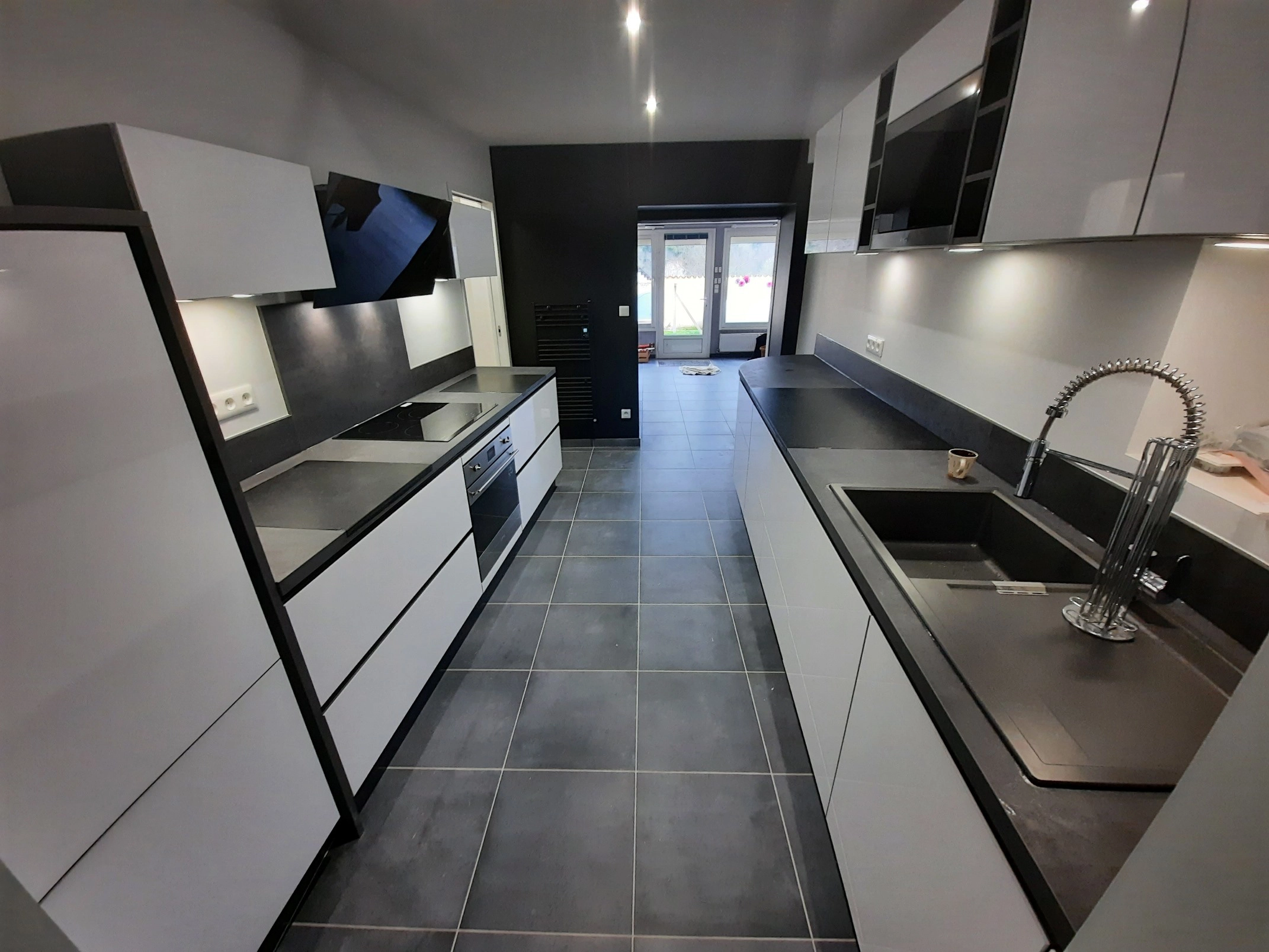 Cuisine en noir et blanc dans un passage avec insert intégré et éclairage LED moderne