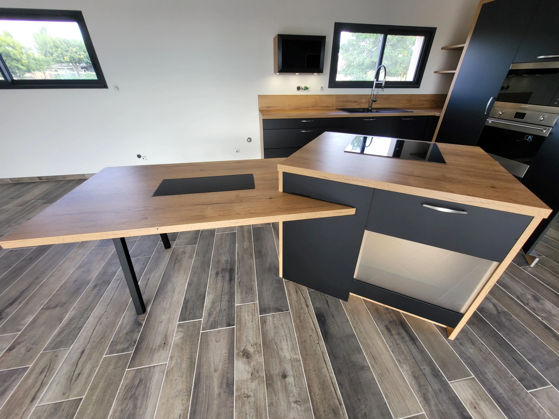 Cuisine moderne avec îlot central en bois et plaques de cuisson intégrées