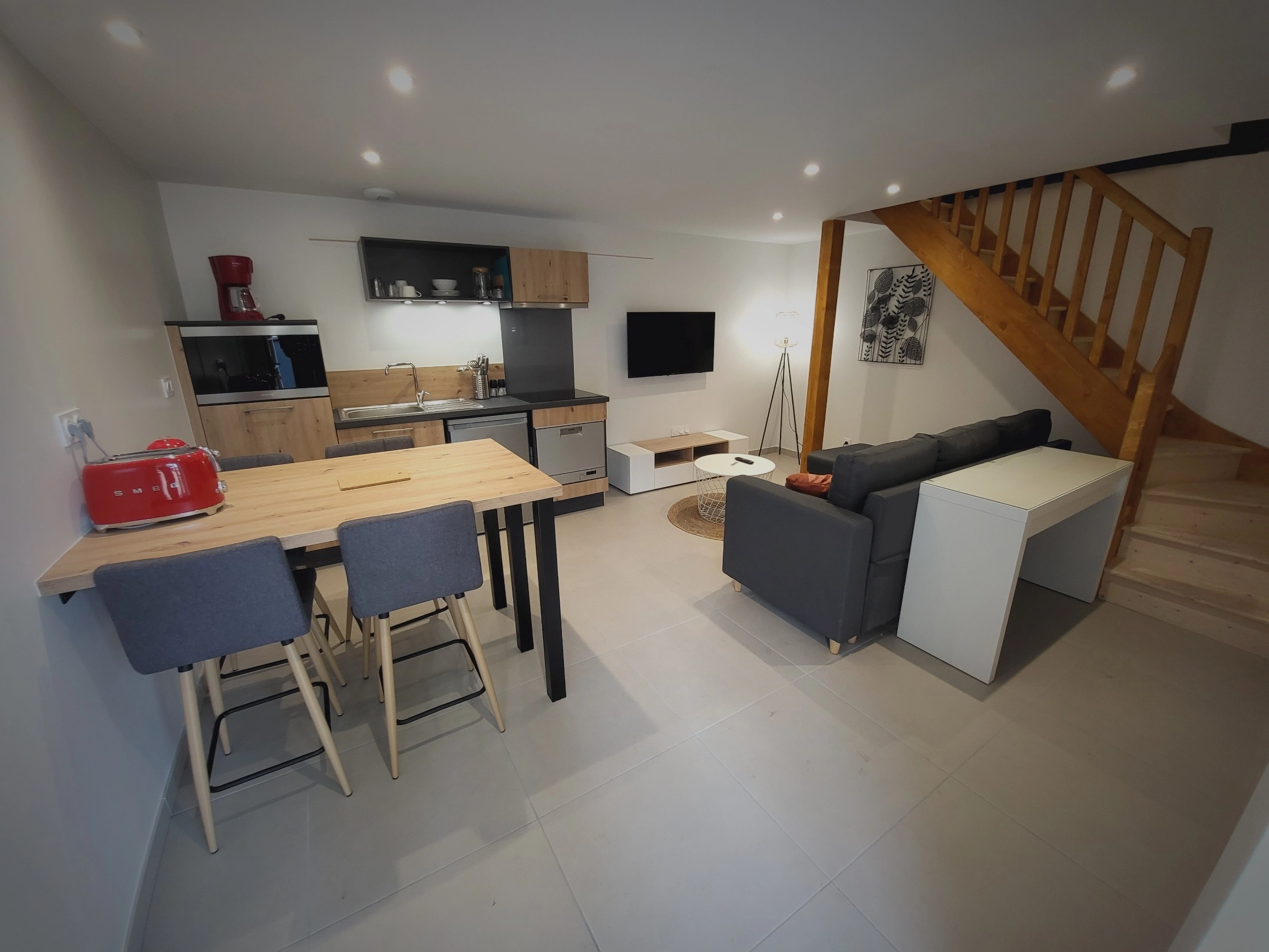 Salon avec cuisine ouverte et escalier en bois